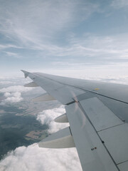 Obraz premium Wing of a plane flying over the clouds