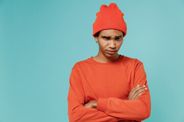 Young offended frowning sad resentful african american man 20s in orange shirt hat hold hands...