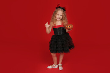 a little blonde girl in a black dress with a headband with horns is a Halloween trait