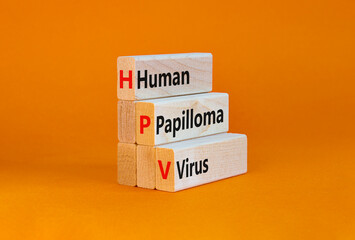 HPV, Human papilloma virus symbol. Concept words HPV, Human papilloma virus on wooden blocks on a beautiful orange background. Medical, HPV, Human papilloma virus concept. Copy space.