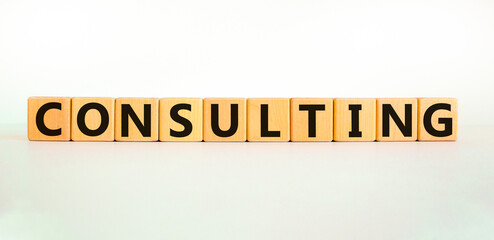 Consulting symbol. The word Consulting on wooden cubes. Beautiful white table, white background. Business and consulting concept. Copy space.