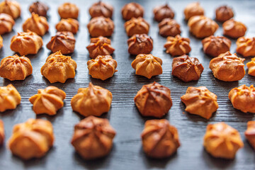 Delicious homemade organic eclairs laid out in a row on a wooden surface.