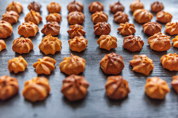Delicious homemade organic eclairs laid out in a row on a wooden surface.