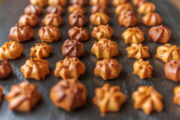 Delicious homemade organic eclairs laid out in a row on a wooden surface.