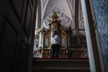 Chica frente a un organo de una iglesia contemplando el lugar