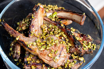 Lamb cutlets chops grilled on barbecue plate with pistachio nut . Backyard BBQ grill cooking. Australia Day celebration