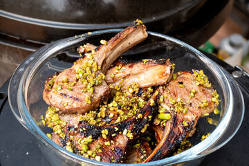 Lamb cutlets chops grilled on barbecue plate with pistachio nut . Backyard BBQ grill cooking. Australia Day celebration