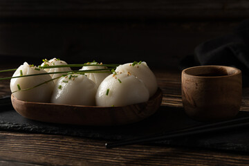 Steamed pork and prawn dim sum on slate stone on wooden table