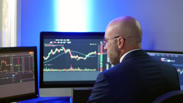 Medium shot of stock broker forex crypto trader man in suit in office analysing charts