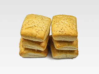 Two stacks of sesame buns on a light background