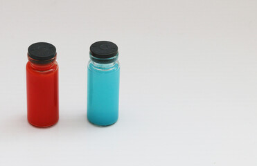 A group of glass multicolored jars with the Covid-19 coronavirus vaccine on a white surface.