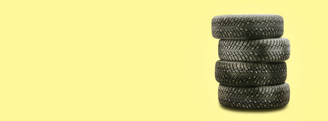 Fototapeta na wymiar studded tires, a set of 4 pieces on a yellow background copy space. seasonal tire change safety