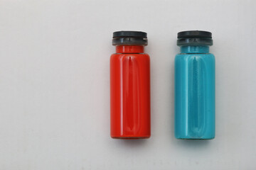 Flatlay of blue and red pharmaceutical vials.