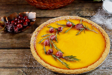 Tasty pumpkin pie with cranberry on rustic background, close up.