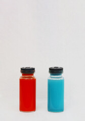 Vial with medicine for injection of red color on blue background.