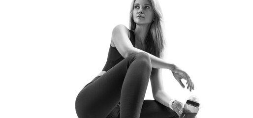 Attractive fitness female model sitting. Black and white closeup portrait isolated on white. Slim,...