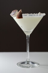 Coconut cocktail in martini glass based on the rum decorated with coconut flakes and coconut pieces