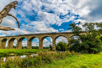 Fototapeta premium A framed view of a train on the Arthington Viaduct in Yorkshire, UK in summertime