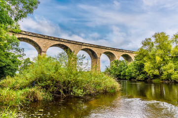 Fototapeta na wymiar A view upstream towards the Arthington Viaduct in Yorkshire, UK in summertime