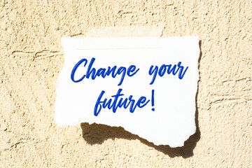 Closeup Blue Sticky Note paste it in a notebook setting an appointment. The words Change your future written on a brown notebook to remind you an important appointment.