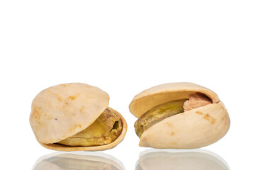 Two unpeeled pistachios, close-up, isolated on white.