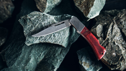 Pocket knife on stone background