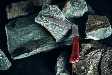 Pocket knife on stone background