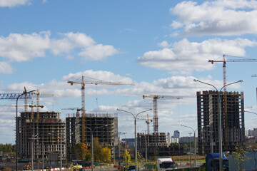 Fototapeta na wymiar Construction of modern multi-storey buildings. Construction of a new city block. Buildings under construction and tower cranes.
