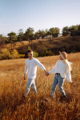 Romantic couple in love walking during autumn sunny day. Love story. Autumn style. Kiss and hugs.