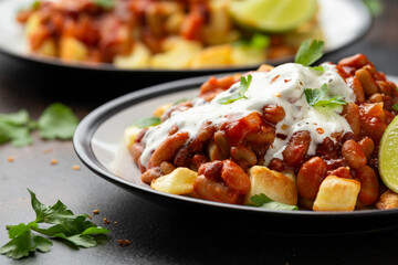 Spicy Bean Chilli with Baked Potato, sour cream and lime. Healthy Food