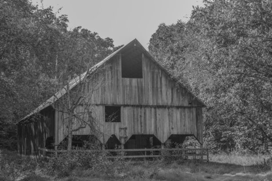 In black and white. Old rundown barn in the wilderness of the mountains in Missouri