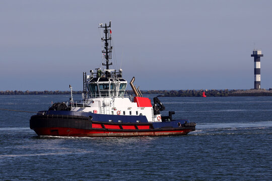 Roter Hafenschlepper im Hafen bei der Arbeit