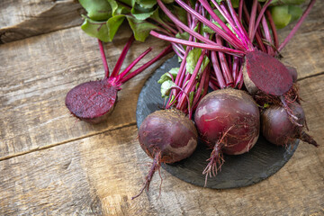 Fresh organic ripe juicy beetroot on a wooden kitchen table. The concept of organic nutrition and autumn harvesting  vegetables. Copy space.