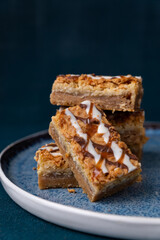 Coconut macaroon cookie bars squares stacked on a dark background