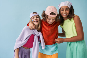 Happy little multiracial friends hug each other