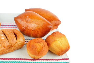 Muffins and sweet buns on a rustic towel isolated on a white .