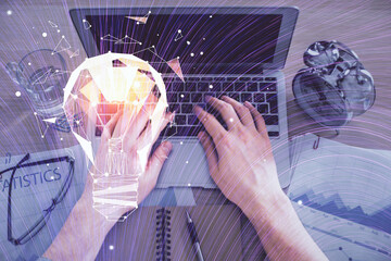 Double exposure of man's hands typing over computer keyboard and bulb hologram drawing. Top view. Idea concept.