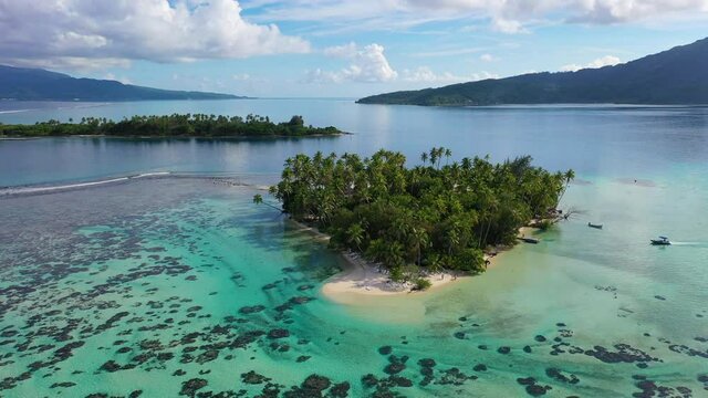 Bora Bora Drone aerial video of small Island paradise. Travel vacation icon of beach private island motu with palm trees. Turquoise crystal lagoon ocean water on Bora Bora, French Polynesia.
