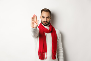 Serious bearded guy saying no, showing stop sign, rejection sign, prohibit action, standing in...