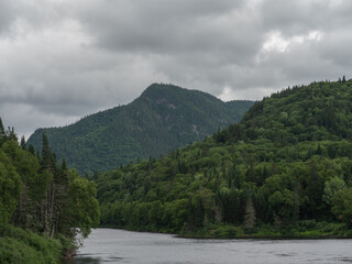 Rivière dans une vallée avec vue sur une montagne durant une journée nuageuse