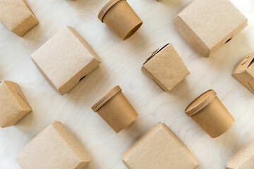 Flat lay of disposable packages for burgers and noodles on wooden texture.