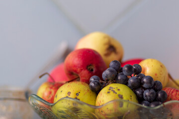 Apples and grapes in a glass dish on the table