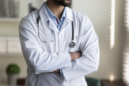 Cropped shot of young male doctor in white coat and stethoscope. Confident general practitioner, medical specialist, physician, counselor standing with folded arms. Medic care profession