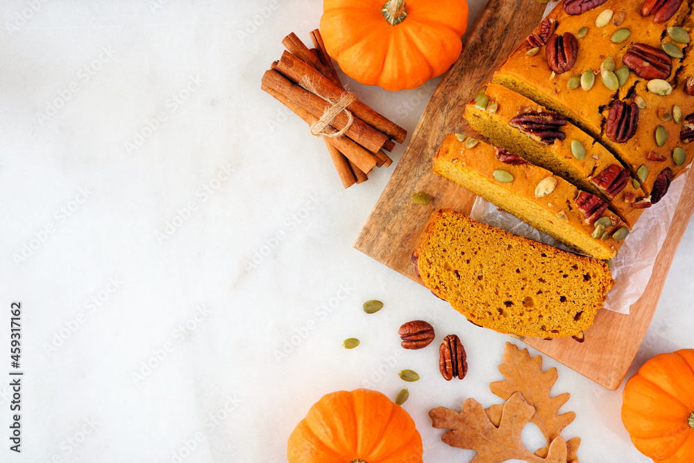 Poster autumn pumpkin bread sliced. above view table scene over a white marble background. copy space.