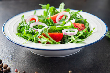 arugula and tomato salad vegetable in a plate fresh portion ready to eat meal snack on the table copy space food background rustic. top view keto or paleo diet veggie vegan or vegetarian food