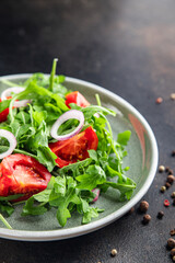 arugula and tomato salad vegetable in a plate fresh portion ready to eat meal snack on the table copy space food background rustic. top view keto or paleo diet veggie vegan or vegetarian food