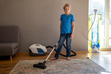 child uses vacuum cleaner to clean house