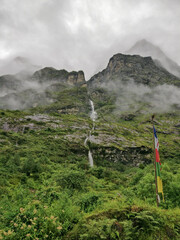 A waterfall falling out of an elevated mountain face in the north east indian state sikkim