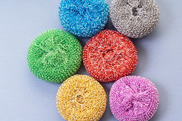Multi-colored sponges for washing dishes on blue background. Steel wool sponge