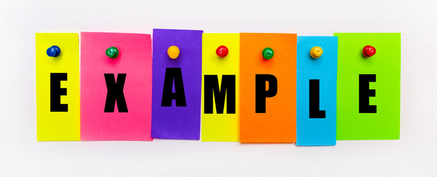 On a white background, buttons are used to fix bright multi-colored strips of paper with the text EXAMPLE